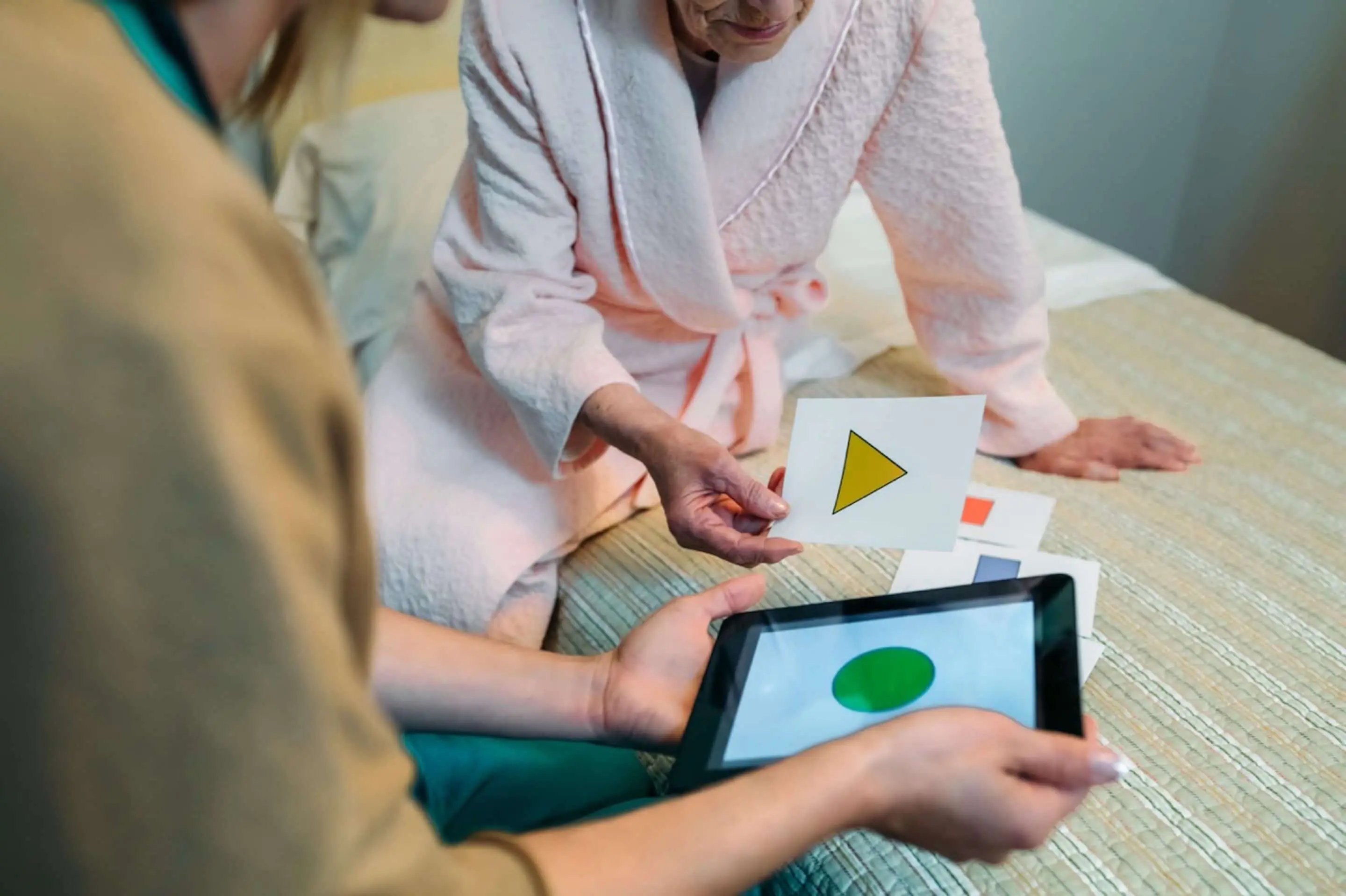 An elderly woman looking at pictures of geometric shapes