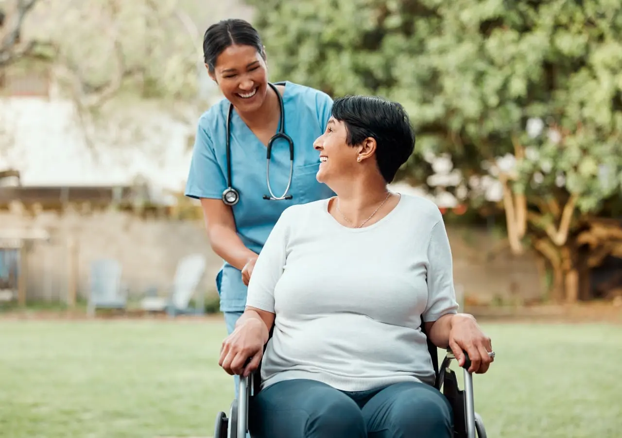 An elderly woman being assisted by a nurse in a long-term care facility