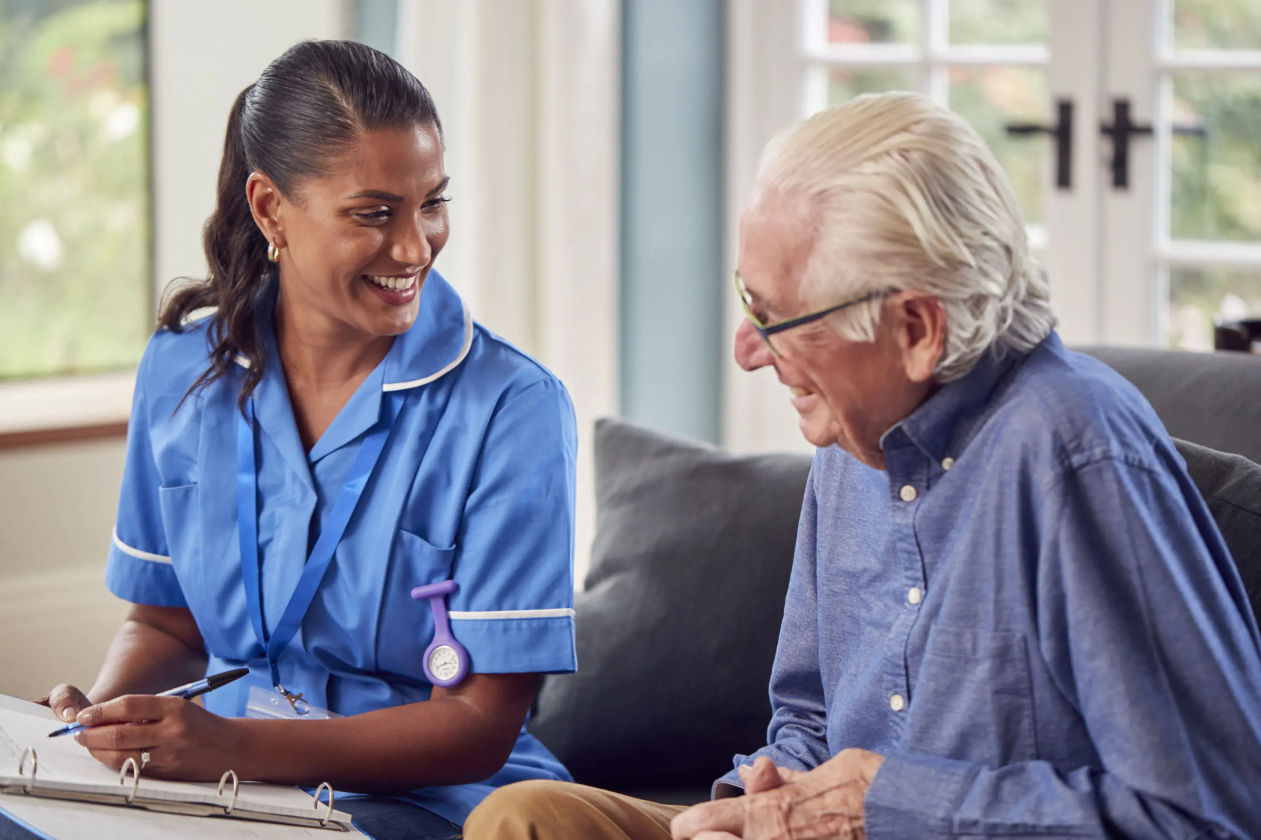 An elderly man talking to a caregiver